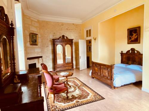 a bedroom with a bed and a desk and a chair at Château Borgeat de Lagrange - privatisation in Blaye