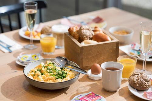 a table with a bowl of food and a box of donuts at Holiday Inn Express Mechelen City Centre, an IHG Hotel in Mechelen