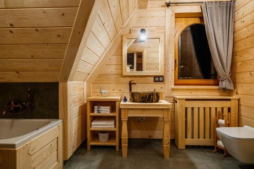 a bathroom in a log cabin with a sink and a mirror at GÓRSKIE DOMKI Murzasichle in Murzasichle