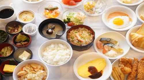 a table topped with bowls of different types of food at Dormy Inn Abashiri in Abashiri