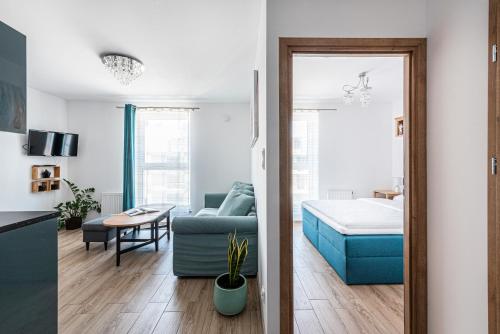 ein Wohnzimmer mit einem blauen Sofa und ein Schlafzimmer in der Unterkunft Apartament Niebieski OPTILOCUS in Danzig