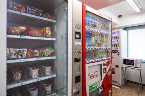 a cocacola soda vending machine in a room at Business Inn Norte in Sapporo