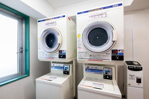 two washing machines and a washer and dryer in a room at Business Inn Norte in Sapporo