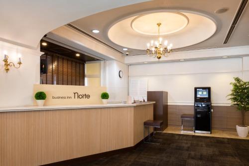 a lobby of a hotel with a reception counter at Business Inn Norte in Sapporo