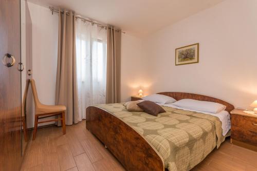 a bedroom with a bed and a chair and a window at Villa Sali in Sali