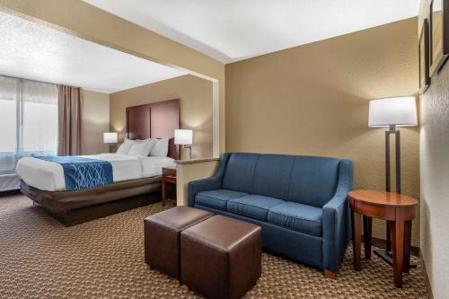 a hotel room with a bed and a blue chair at Comfort Inn Near Kokomo Speedway in Kokomo