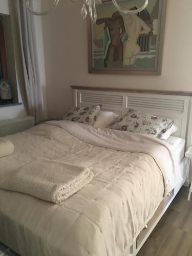 uma cama branca num quarto com uma fotografia na parede em Mazurska Villa Deluxe w Pasymiu z prywatnym pomostem na jezioro Kalwa i łodzią na wyłączność Najwyższe Premium w Osada Zamkowa em Pasym