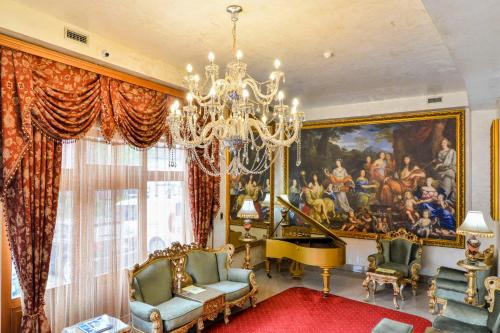 a living room with a painting and a chandelier at Premier Prezident Garni Hotel and Spa in Sremski Karlovci