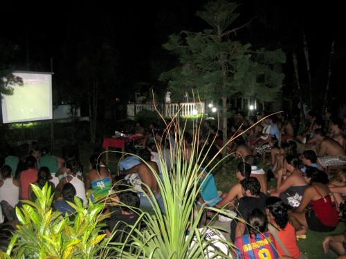 a crowd of people watching a presentation at night at Jungle Safari Resort in Sauraha