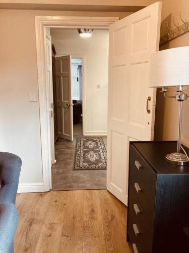 a living room with a door and a lamp on a table at Stunning Stylish & Spacious Ground Floor Apartment, Kidderminster in Kidderminster