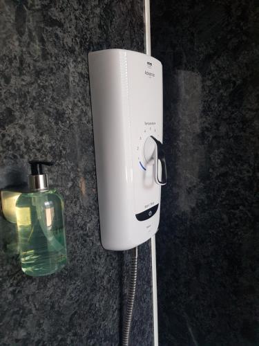 a soap dispenser on a wall next to a bottle at The Old Cross Inn in Blairgowrie