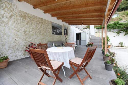 einen Tisch und Stühle auf der Terrasse eines Hauses in der Unterkunft Hotel Erviliano in Borsh