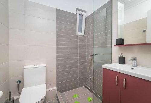a bathroom with a toilet and a sink and a shower at Sivylla Apartments in Lefkada