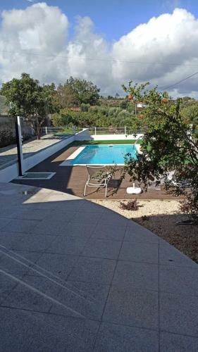 a swimming pool with a table and a chair next to it at Casa do Chão do Cruzeiro in Arcozelo