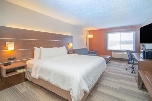 a hotel room with a bed and a television at Holiday Inn Express Houghton-Keweenaw by IHG in Houghton