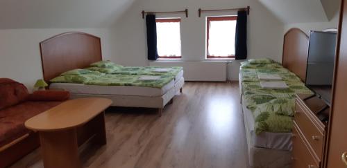 Habitación con 2 camas, mesa y sofá en Borgaléria en Tokaj