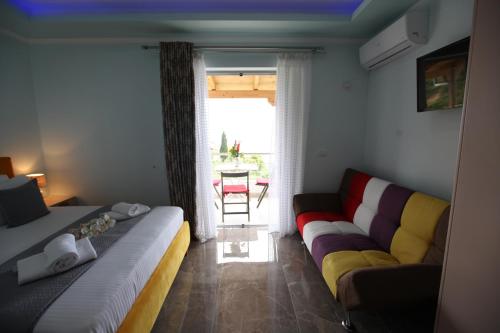a room with a bed and a couch and a window at Hotel Erviliano in Borsh