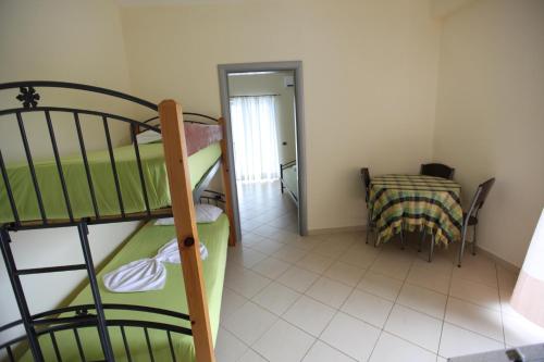 a small room with a bunk bed and a table at Hotel Erviliano in Borsh