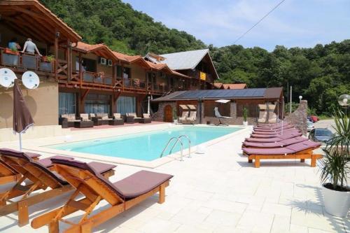 um resort com uma piscina com espreguiçadeiras em Pensiunea Deian-Clisura Dunării em Moldova Nouă