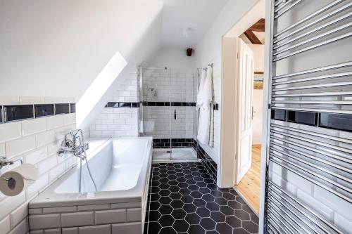 a bathroom with a white tub and a sink at Vila Čapek in Branžež