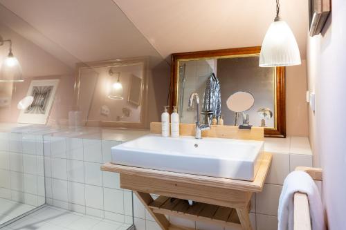 W łazience znajduje się biała umywalka i lustro. w obiekcie Gut Sonnenhausen w mieście Glonn
