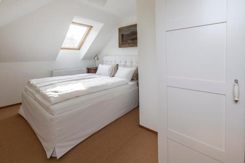 a bedroom with a white bed and a window at Vila Čapek in Branžež