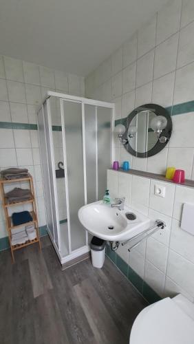 a bathroom with a sink and a mirror and a toilet at Pension Hanni in Ostseebad Sellin