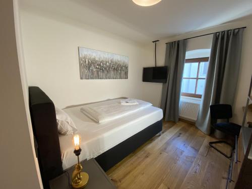 um pequeno quarto com uma cama e uma janela em Hotelgasthof Kirchenwirt em Schierling