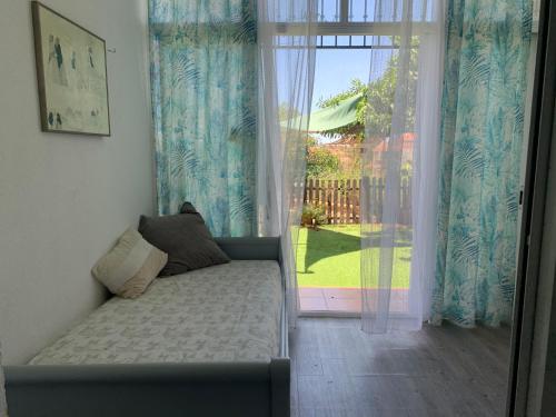 a couch in a room with a sliding glass door at Apartamento con jardín y piscina en el faro de calaburras in Mijas Costa