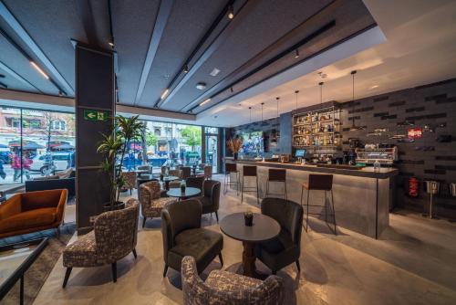 a restaurant with tables and chairs and a bar at Catalonia Gran Vía Bilbao in Bilbao