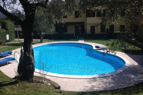 a large blue swimming pool next to a building at Casa Mirella - Toscolano Maderno in Toscolano Maderno