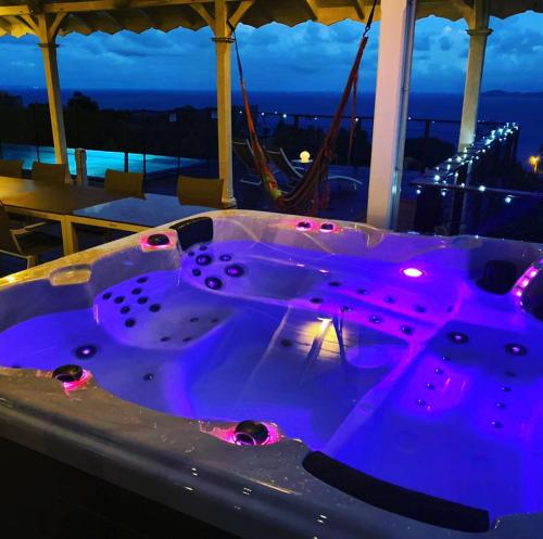 a jacuzzi tub sitting on top of a balcony at night at Villa Cajou chambres d'hôtes chez l'habitant et Zanzibar cottage in Trois-Rivières