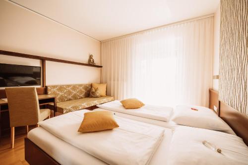 a hotel room with two beds and a desk at Weingut Brenner am Rossberg in Glanz an der Weinstraße 