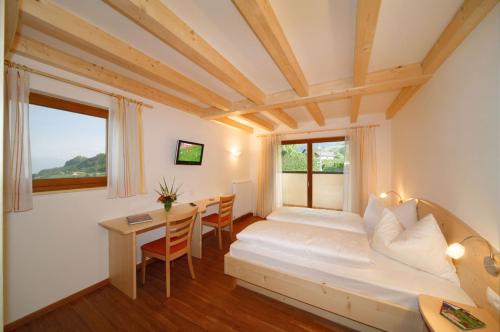 1 dormitorio con 1 cama y 1 mesa con sillas en Gasthof Falger, en Foiana - Völlan