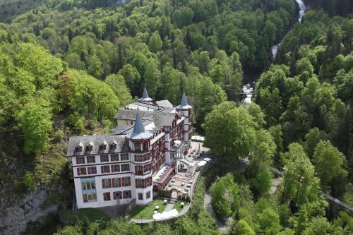 eine Luftansicht einer Burg inmitten eines Waldes in der Unterkunft Grandhotel Giessbach in Brienz