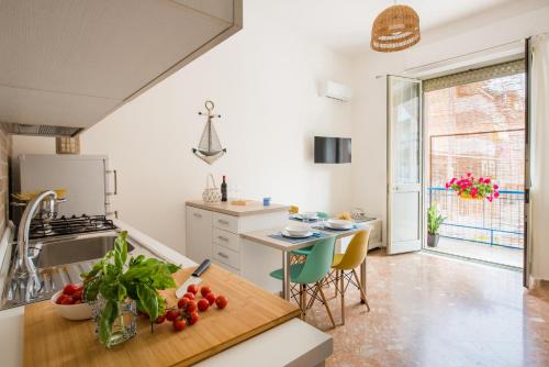 una cocina con fregadero y una mesa con tomates en VENTO DI SCIROCCO CASA VACANZE A POCHI METRI DAL MARE, en Santa Flavia