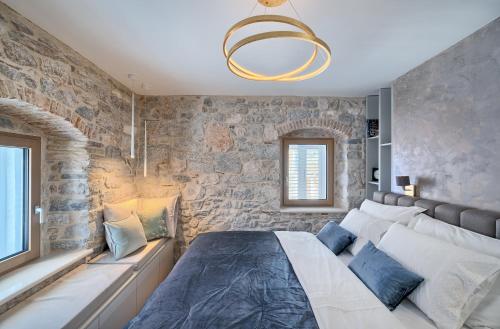 sypialnia z łóżkiem i kamienną ścianą w obiekcie Magnolia Luxury Rooms w Splicie