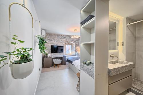 a bathroom with a sink and a bed in a room at Magnolia Luxury Rooms in Split