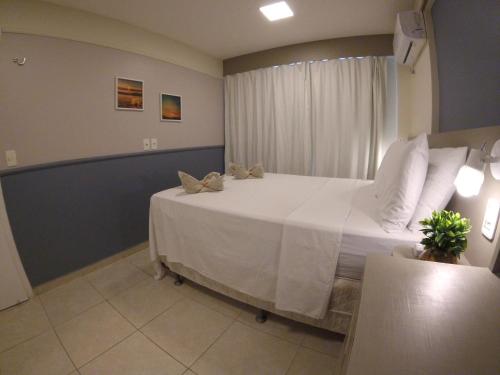 1 dormitorio con 1 cama grande con sábanas blancas en Relaxe Vista Mar 2 Quartos no Beach Village, en Fortaleza