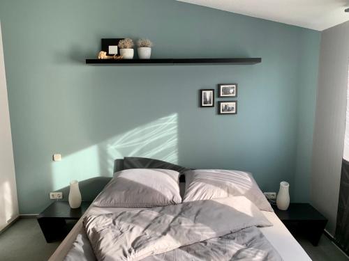 a bedroom with a bed with a blue wall at MEINE OASE Ferienwohnung !!! NICHT FÜR MONTEURE !!! in Horn-Bad Meinberg