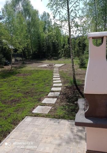 a stone path in a park with a tree at ApartDomek CICHE in Zbiczno