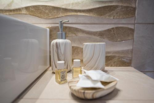 eine Badezimmertheke mit einer Flasche Seife und einem Waschbecken in der Unterkunft Liovore Apartments in Lygia