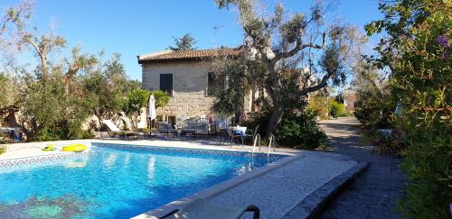 a swimming pool in front of a house at Casa Ulmi con piscina in Uggiano la Chiesa