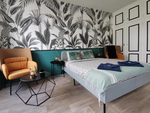 - une chambre avec un lit et un mur orné de plantes dans l'établissement Jungle studio Gex - Ski - Netflix, à Gex