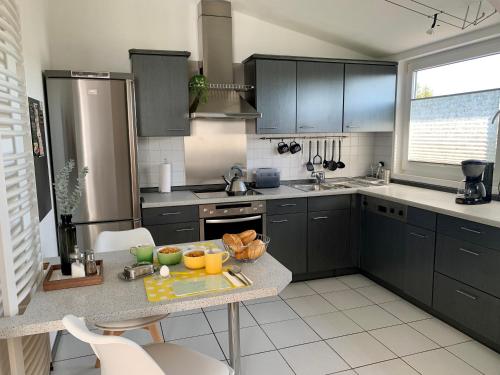 a kitchen with black cabinets and a table with fruits on it at MEINE OASE Ferienwohnung !!! NICHT FÜR MONTEURE !!! in Horn-Bad Meinberg