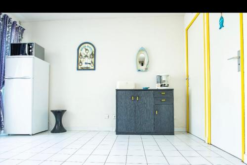 La cuisine est équipée d'une armoire noire et d'un réfrigérateur. dans l'établissement Bright Apt With Terrace In La Grande Motte, à La Grande Motte