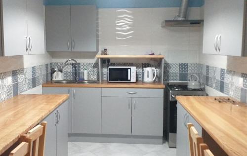 a kitchen with white cabinets and a microwave at Zajazd na Podzamczu in Pieskowa Skała