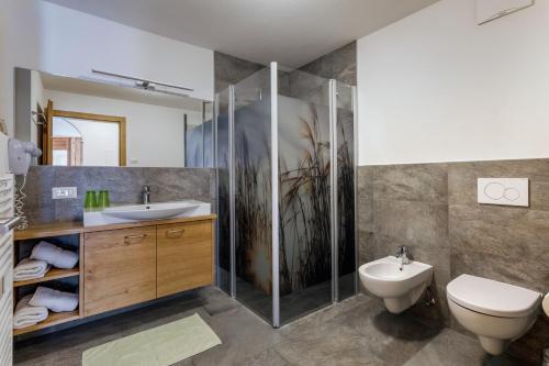 ein Bad mit einer Dusche, einem WC und einem Waschbecken in der Unterkunft Zangerlehof in Slingia