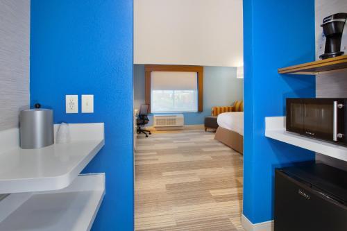 a room with blue walls and a bed and a television at Holiday Inn Express & Suites Wooster by IHG in Wooster