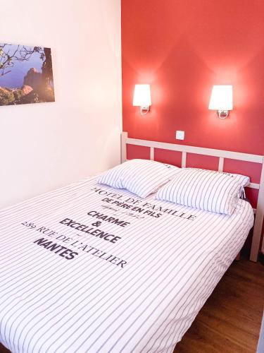 a bedroom with a white bed with a red wall at Residence Cap Esterel Babou in Saint-Raphaël